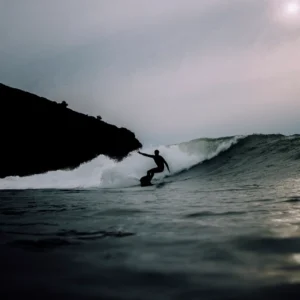 person wearing wetsuit surfing wave